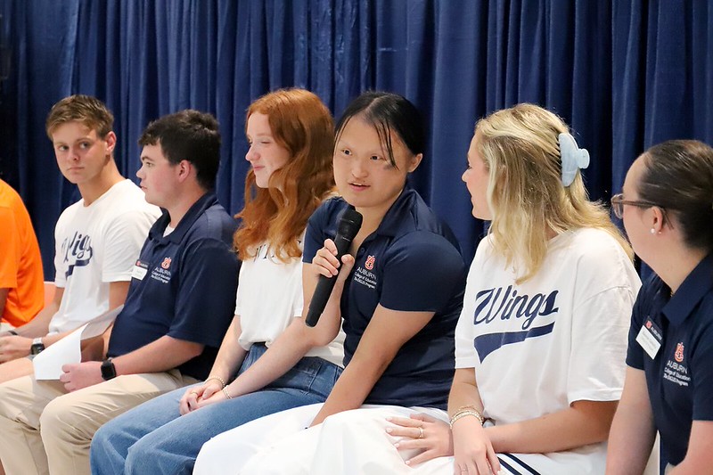 A panel of current eagles students speaks to the crowd.