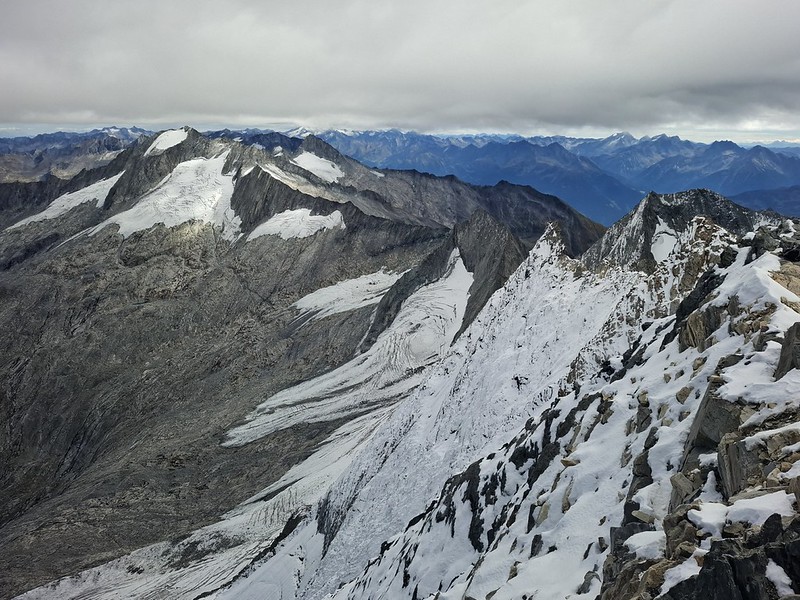 20260913-051W | Tiefblick vom Gipfel des Hochfeilers (3509 m) in die steile Nordwand und auf die kläglichen Reste des Schlegeiskees. Links der Große Möseler (3480 m), im Hintergrund Venedigergruppe, Großglockner (3798 m, in Wolken) und Rieserfernergruppe. Zillertaler Alpen, 13.09.2026