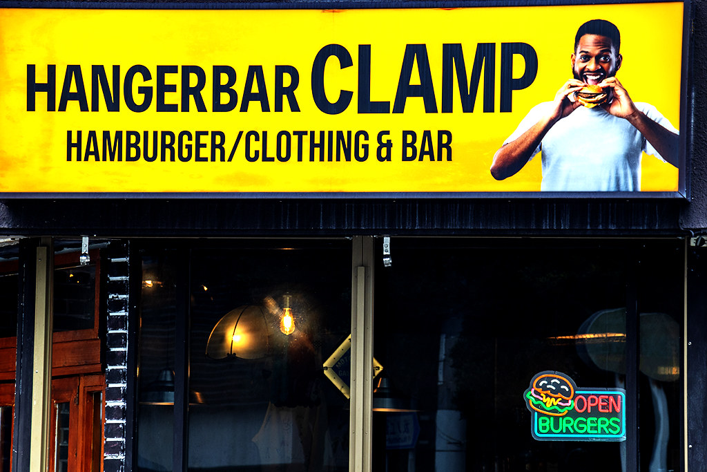 Black man eating a cheeseburger on sign of Hangerbar on 9-27-26--Naha copy