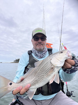 Man on a small boat holding a fish