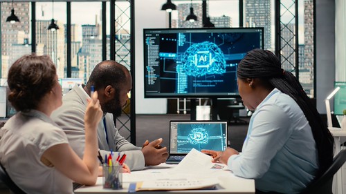 A photo of people examining an AI screen