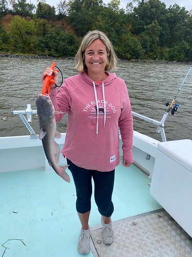 Woman on a boat holding a fish