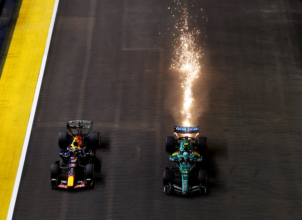 SINGAPORE, SINGAPORE - OCTOBER 11: Sparks fly behind Fernando Alonso of Spain driving the (14) Aston Martin F1 Team AMR26 Honda as he battles Isack Hadjar of France driving the (6) Oracle Red Bull Racing RB22 Red Bull Ford Powertrains for track position during the F1 Grand Prix of Singapore at Marina Bay Street Circuit on October 11, 2026 in Singapore, Singapore. (Photo by Joe Portlock/Getty Images) // Getty Images / Red Bull Content Pool // SI202610110380 // Usage for editorial use only //