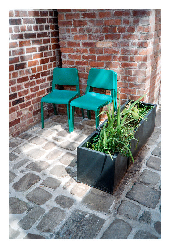Three green chairs and a planter