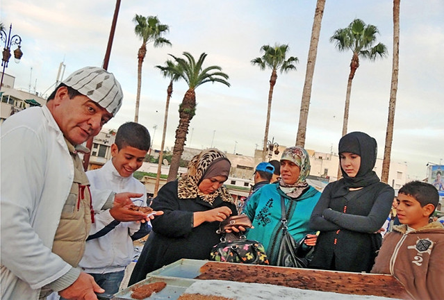 Morocco. Tanger, street-vendor selling out pieces of sweet-pie at Grand Socco
