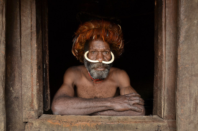 Dani man looking out from his hut door, Papua