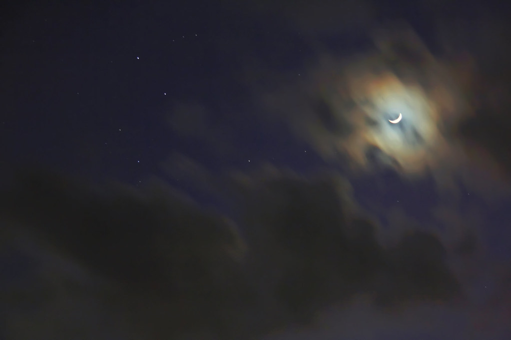 crescent moon through clouds