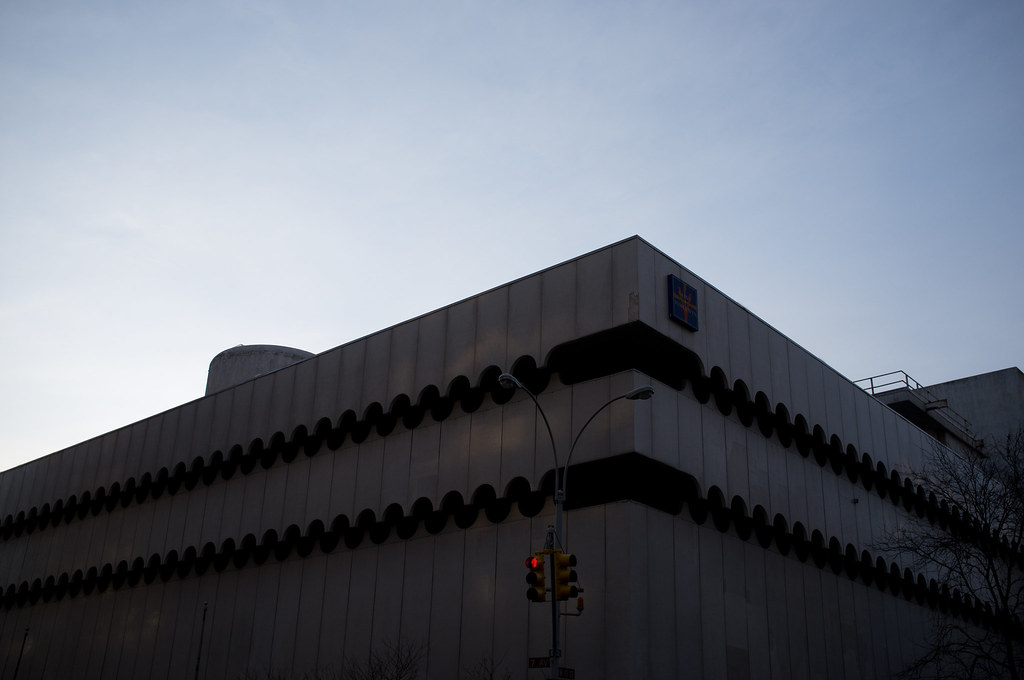 Brutalist telephone switching building with scalloped horizontal vent bands against a pale evening sky.