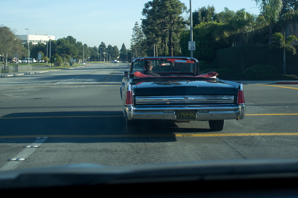 Black Lincoln Continental convertible at a sunny California intersection with a Michigan license plate.