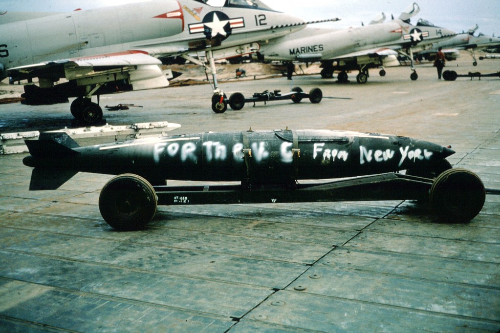 2000 lb Bomb ready to be loaded on VMA 225 A4C Skyhawk Aircraft at SATS airstrip at Chu Lai, Viet Nam; June 1, 1965  Writing on Bomb reads " For the VC from New York "