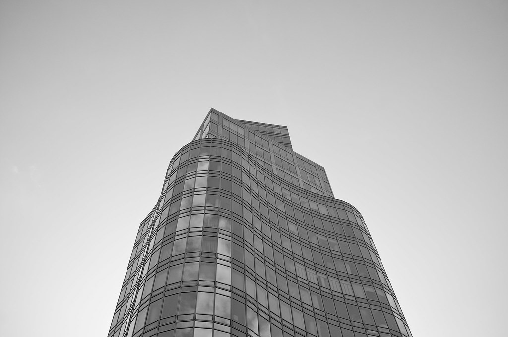 Architectural view looking up at the curved glass facade of the Standard East Village skyscraper.