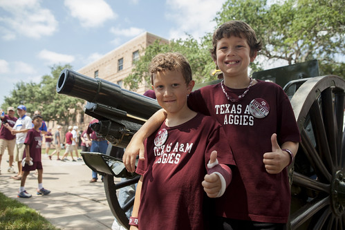 Young Aggies beside cannon