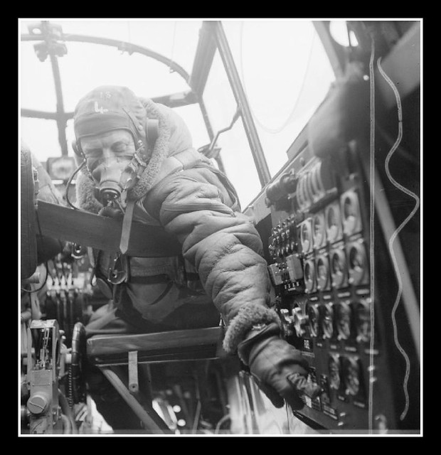 Flying Officer J B Burnside, the flight engineer on board an Avro Lancaster B Mark III of No. 619 Squadron RAF based at Coningsby, Lincolnshire, checks settings on the control panel from his seat in the cockpit.