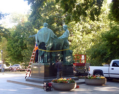 Man works around base of statue for the removal of the Alma Mater for restoration