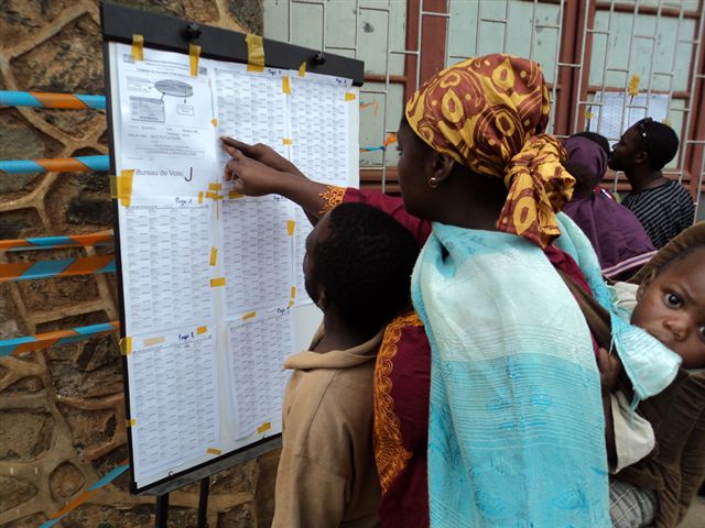 Des électeurs parcourent les listes électorales dans un centre de vote (Collège Alfajiri) à Bukavu