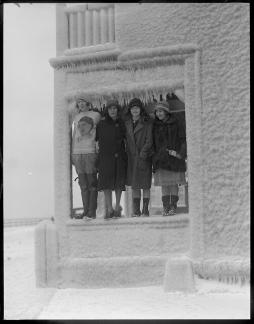 Ethel M. Padden, Blanche Rupp, Elinor Rourke, and Anna Shapiro stand in porch of ice covered house on Shore Drive, Winthrop