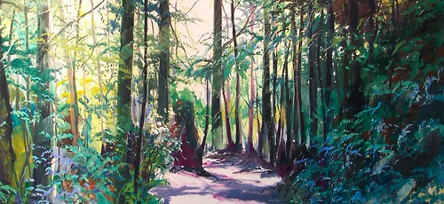 Forest path among green trees and carved poles