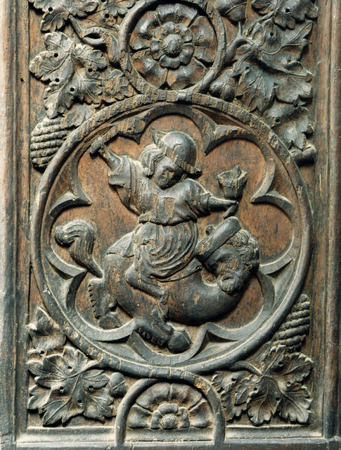 A man - ringing bells with each hand - riding a two-legged hybrid, probably a manticore
