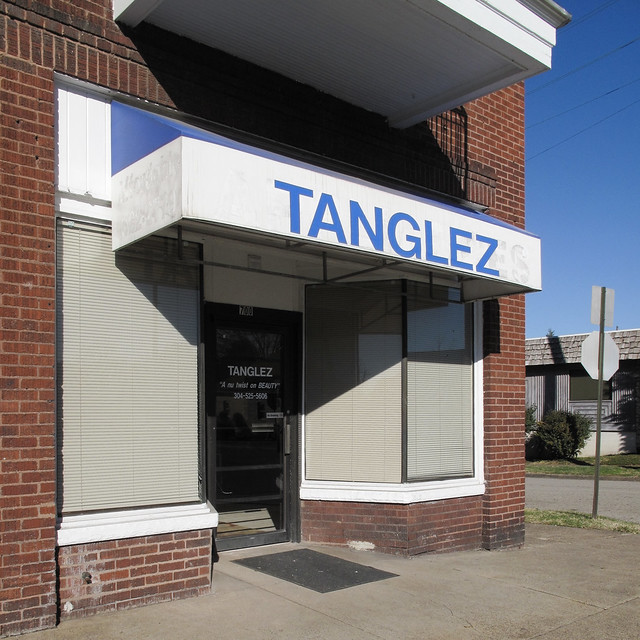 A picture of the noticeable differential between the respective widths of the Tanglez storefront and the Tanglez awning.