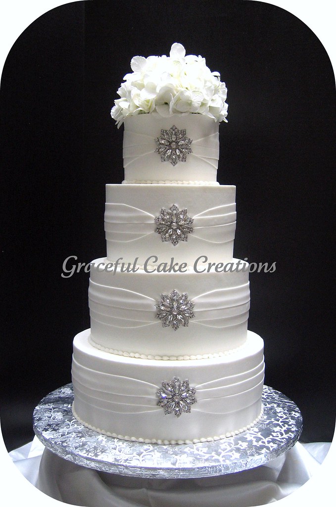 Elegant White Wedding Cake with Silver Brooches