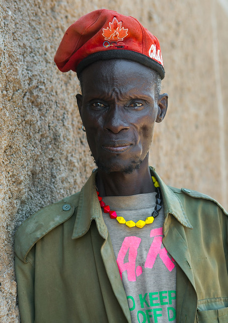 Toposa tribe man with a olympic games canadian red beret, Omo valley, Kangate, Ethiopia