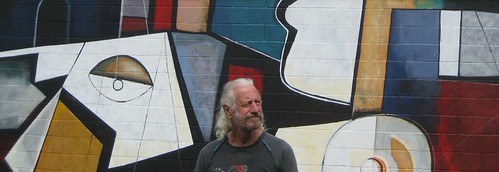 Artist beside geometric mural figures