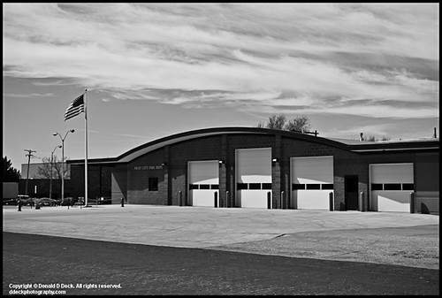 Fire Station with USA Flag, door sky urban brick stone landscape fire photography midwest photographer unitedstates flag ks unitedstatesofamerica stock structures americanflag bluesky safety firetruck fireman kansas firestation emergency firefighter household firedepartment atmospheric goverment urbanlandscape pratt usaflag dddeckcom