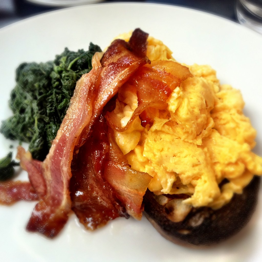 Scrambled eggs on toast with bacon and spinach at Speakeasy