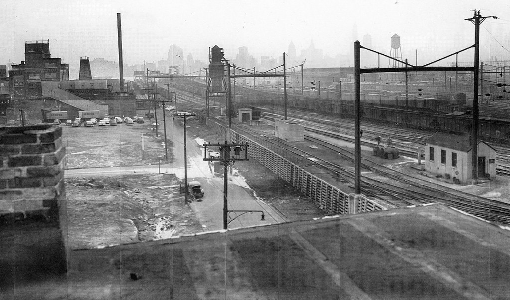 Long before Newport was built, this area was occupied by the Pennsylvania Railroad’s Harsimus Cove train yards.  Lower Manhattan skyline in the smoggy distance. Jersey City. 1951