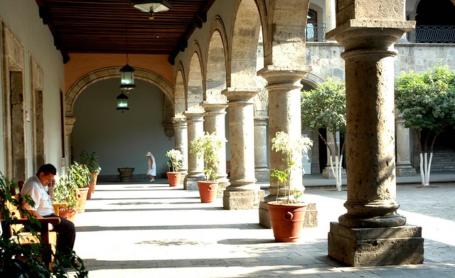 Visitors under the colonade, potted plants, arch, walkway, lamps, trees, stone, graceful proportions in architecture, Governor's Palace, Guadalajara, Jalisco, Mexico