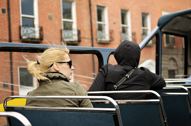 Young blond woman sitting on an open top bus in Dublin - Ireland