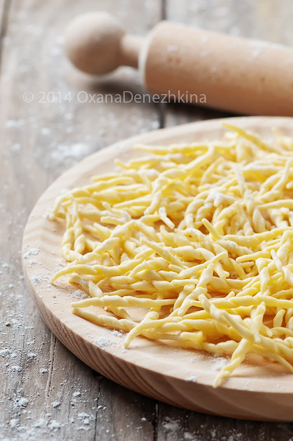 Italian traditional raw pasta trofie on the wooden table