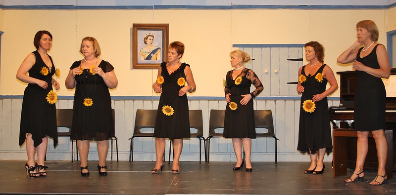 Calendar girls on stage six with sunflowers
