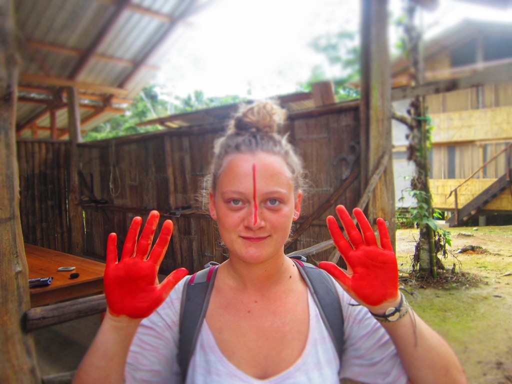 A girl shows her red painted achiote palms in Tena, Ecuador