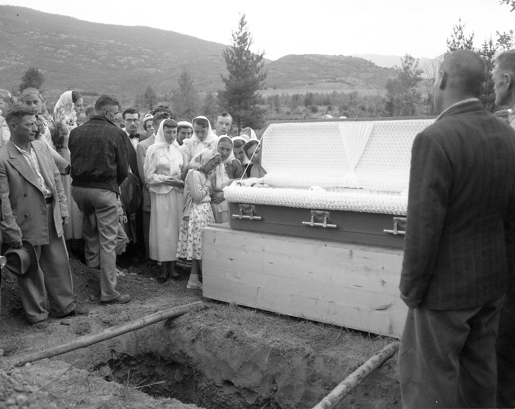 Open casket, open grave, mourners, at funeral of Mary Gienger.