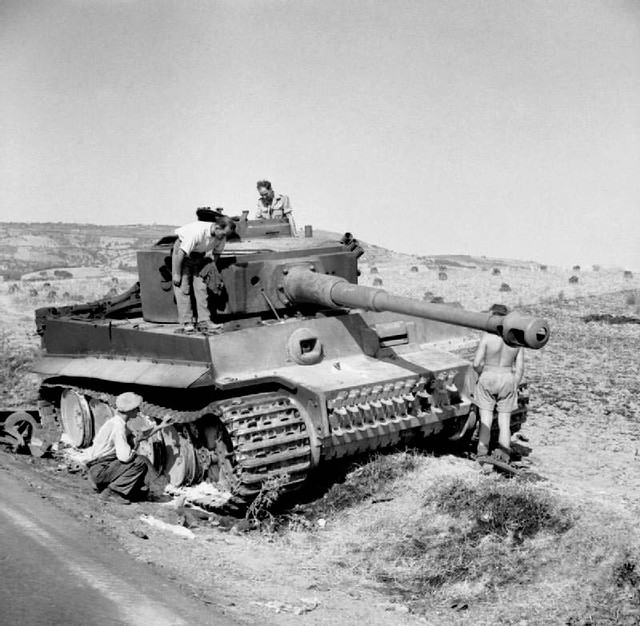 British troops and local civilians examine a knocked-out German PzKpfw VI Tiger tank, 19 July 1943.