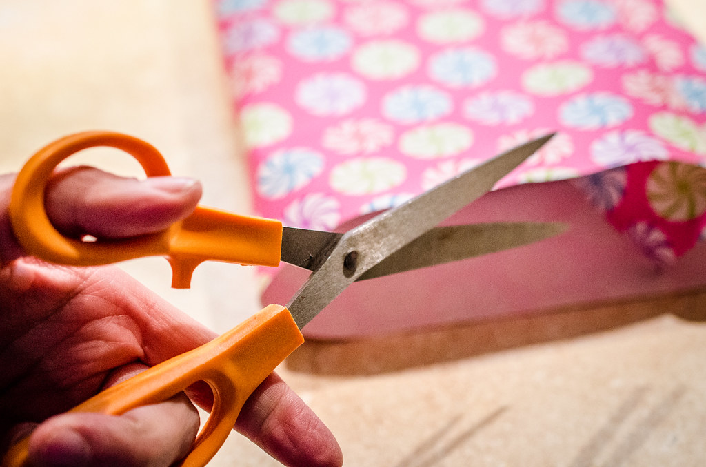 Cutting wrapping paper with scissors, m01229