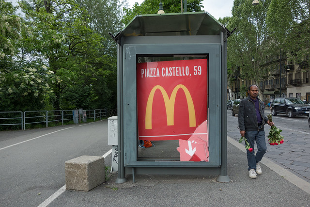 Migrant traffic florist, with smashed McDonald's sign. Torino, May 2013.