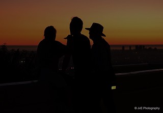 Silhouettes of tourist observing sundown over Los Angeles