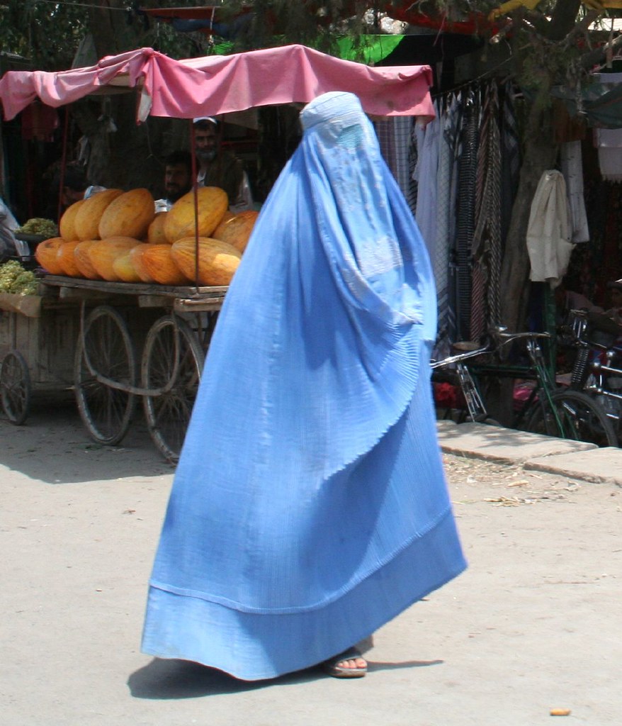 Blue burqa'd woman flying through the streets of Afghanistan.