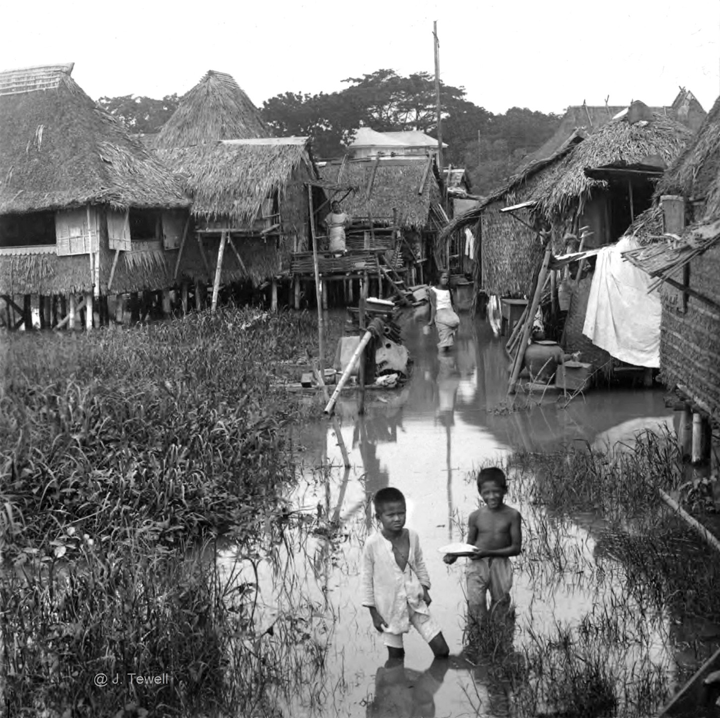 Flood tide in the outskirts of Manila among homes built on piles, early 20th Century, Philippines
