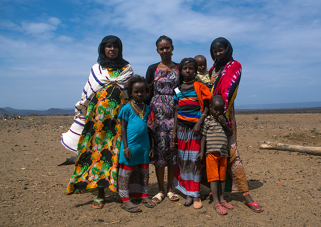 A karrayyu tribe girl called aliya who was the first girl educated in her tribe pausing with her family, Oromia, Metehara, Ethiopia