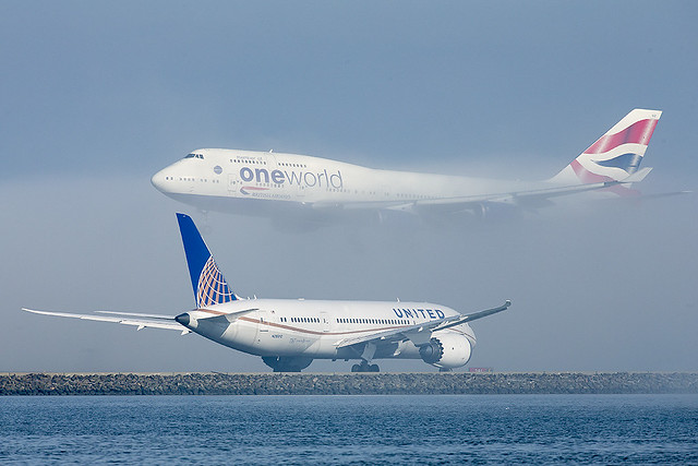 Oneworld (British Airways) Boeing 747-436 G-CIVZ comes out of the fog landing over United Airlines Boeing 787-8 Dreamliner N26910