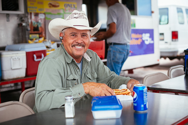 Bluetooth Cowboy eating a Sonoran hot dog
