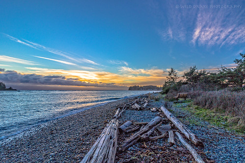 XMAS Eve sunset on Vancouver Island by Drake Dyck Photography, blue trees sunset sky orange water clouds rocks waves logs vancouverisland pacificocean shore christ