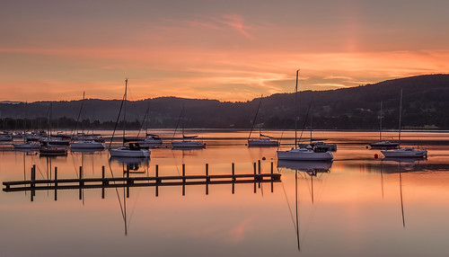 coniston lakedistrict cumbria sunrise conistonwater canon5ds landscapephotography water reflections golder red orange amazing peaceful calm calming boats pier clouds sky fells hills