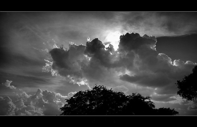 Black and white dramatic cloudscape with rays of light piercing through the clouds.