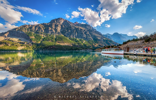 old mountain reflection clouds boat wooden still montana colorful day cloudy ngc calm glacier passengers serene glaciernationalpark boarding stmaryslake littlechief