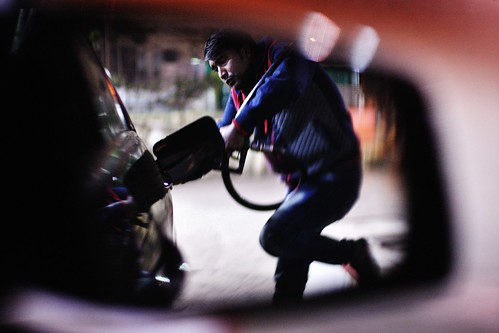 employee worker gasstation khanbrothers night octane sideview mirror reflection candid portrait street dampara chittagong bangladesh availablelight