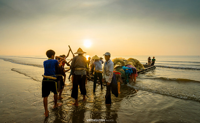 Unknown Fishermen who pull up th are the fishing nets khi sunrise. This is ask for their daily work